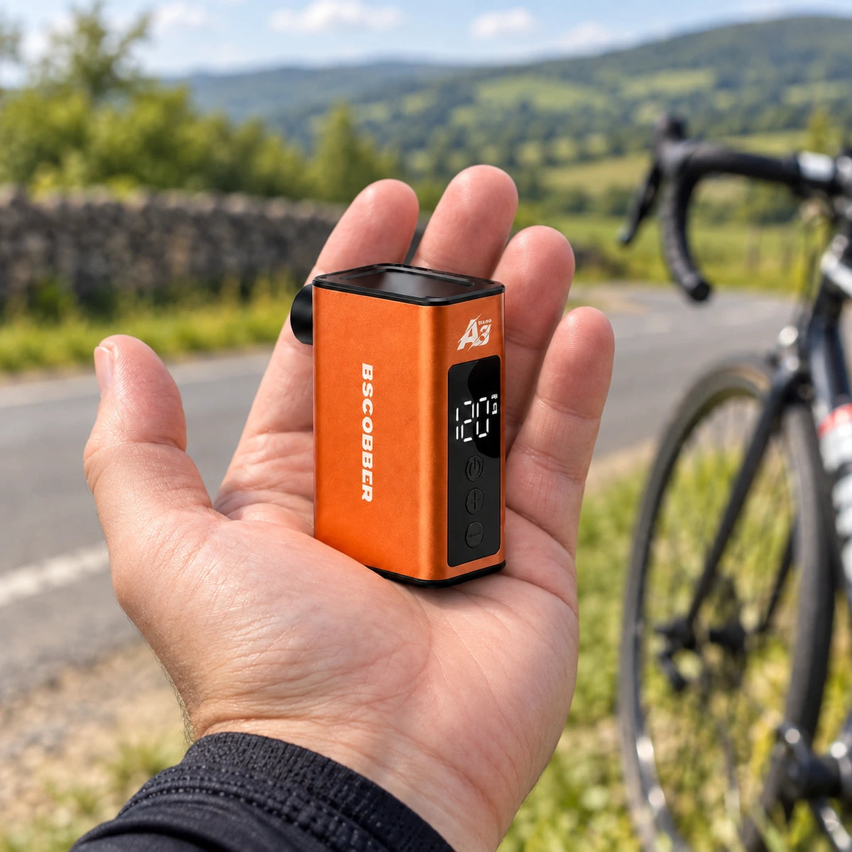 Mini-pompe électrique A3Nano orange dans la main d’un cycliste